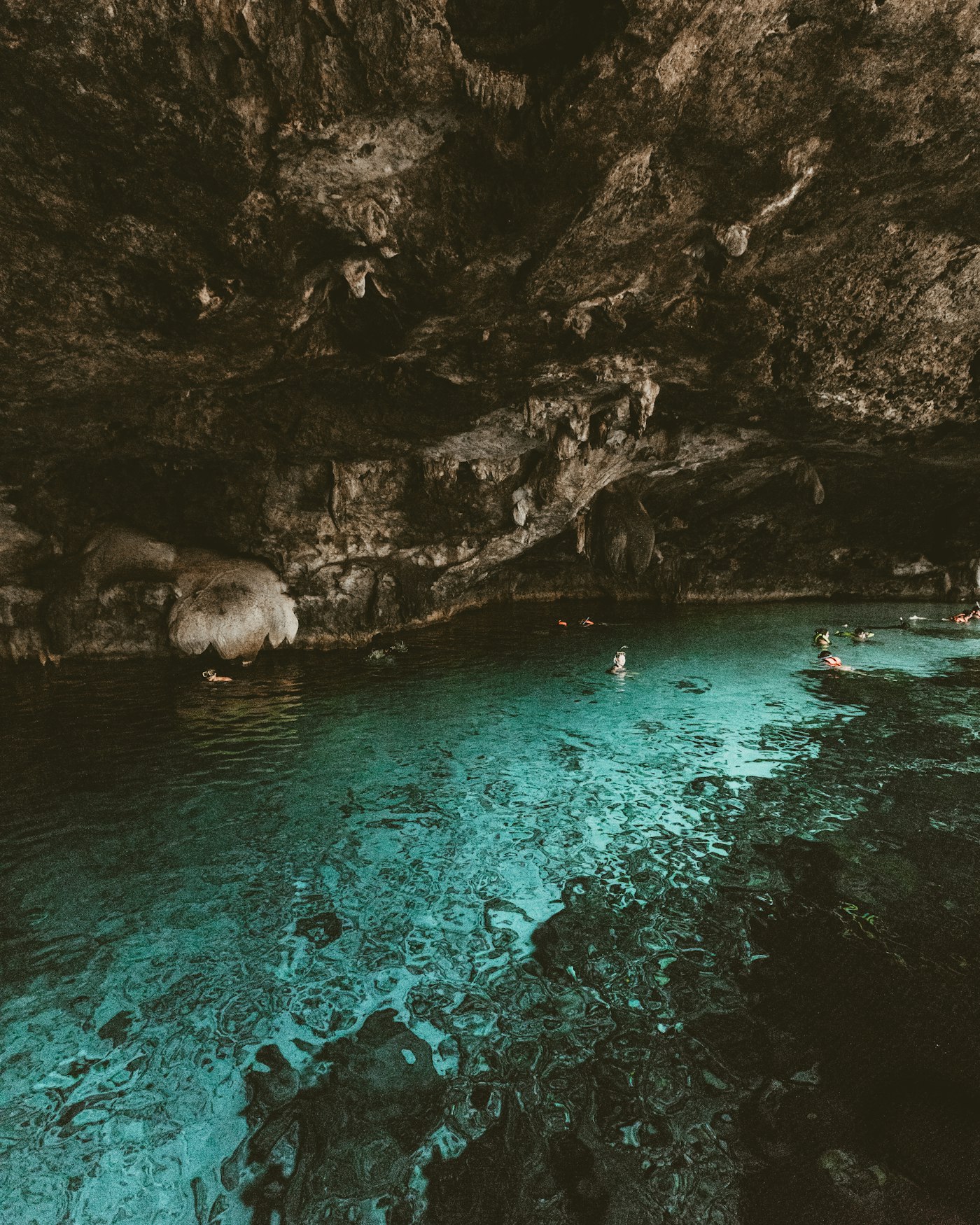 People swimming in a cave cenote